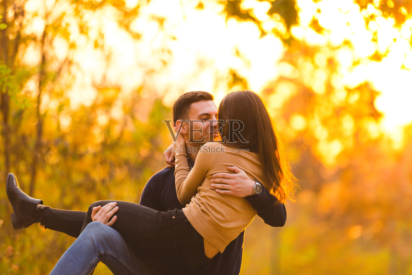 快乐的女友被男朋友抱在怀里笑个不停。照片摄影图片