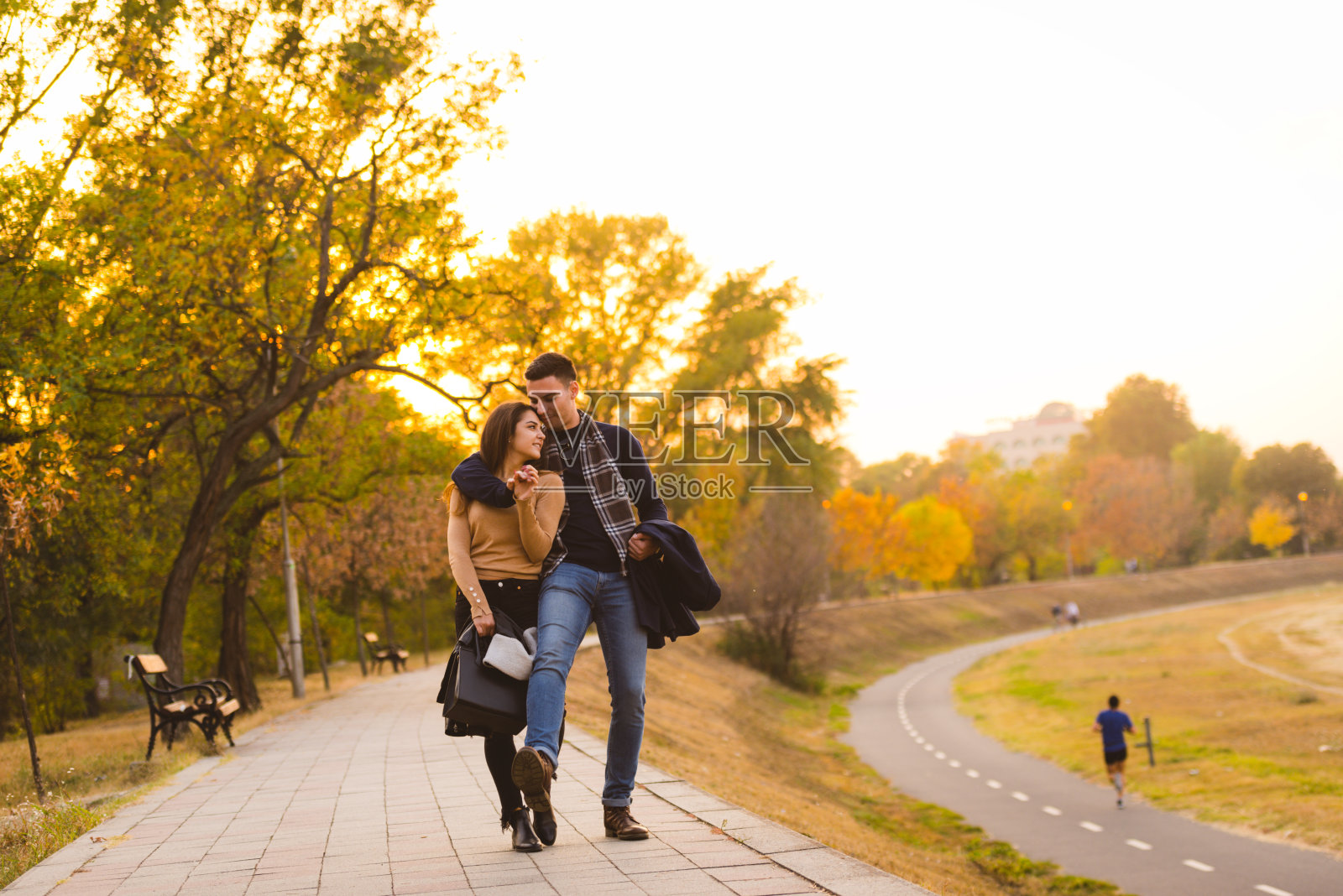 一对情侣在日落前在公园里跳舞。照片摄影图片