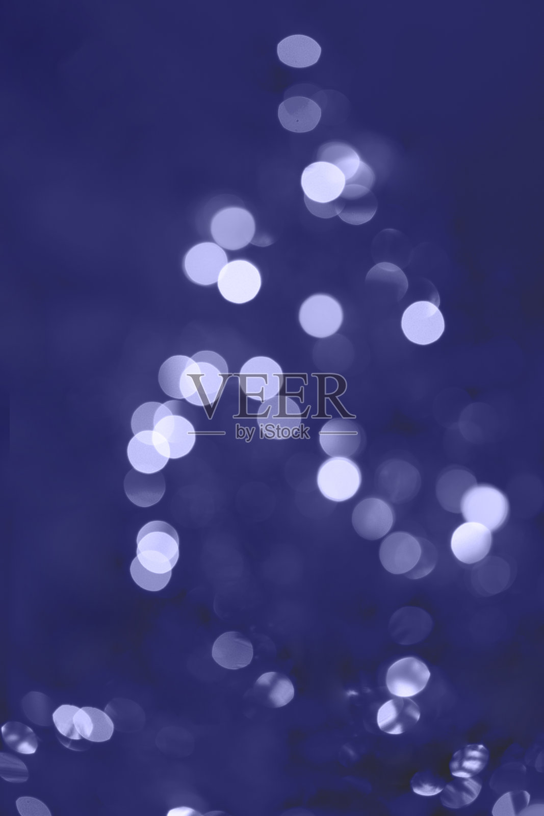 圣诞树上模糊的圣诞彩灯。模糊抽象的圣诞花环在非常佩里的颜色。照片摄影图片