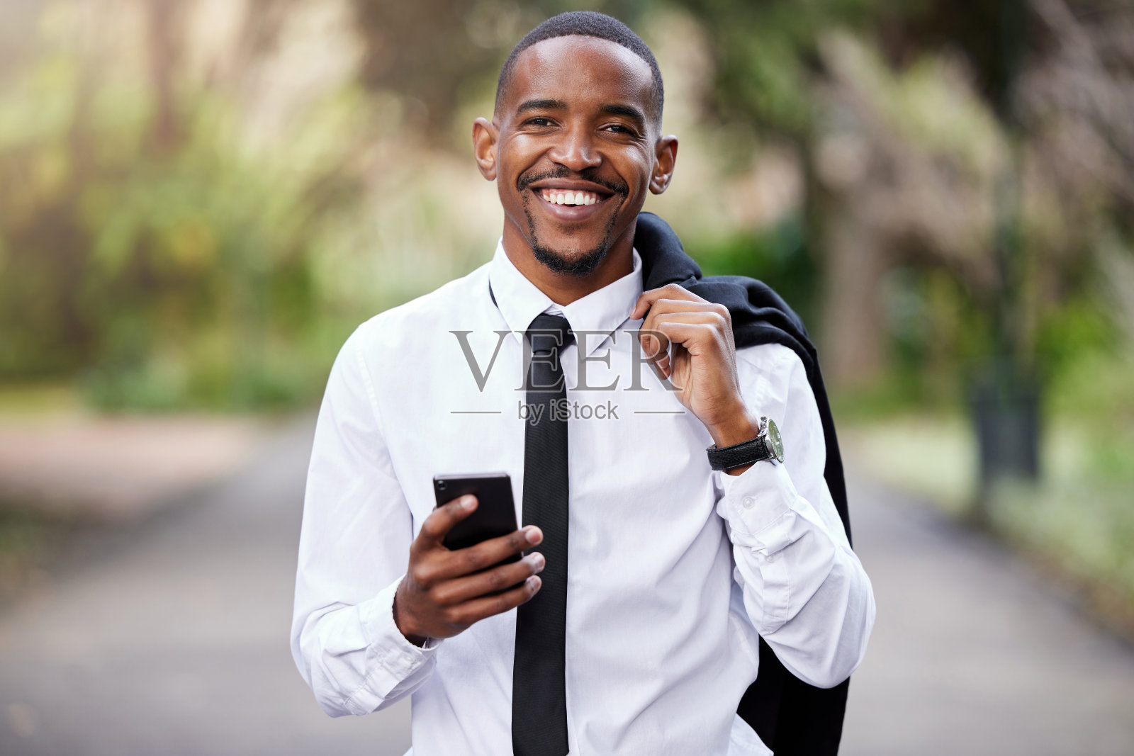 一个年轻的商人在城市里使用手机的照片照片摄影图片