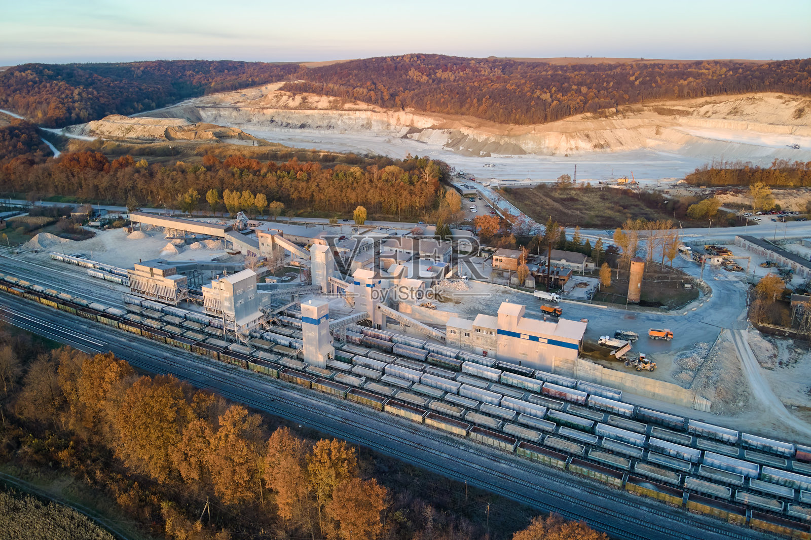 矿山工厂装载碎砂岩材料的货运火车鸟瞰图,露天矿石铁路运输照片摄影图片
