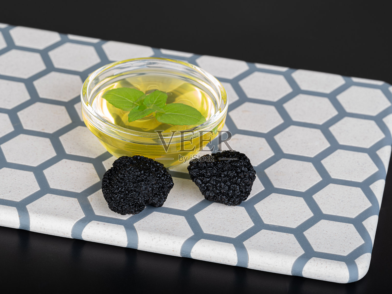 黑松露,蘑菇和松露油放在玻璃碗里,放在切菜板上。俯视图照片摄影图片