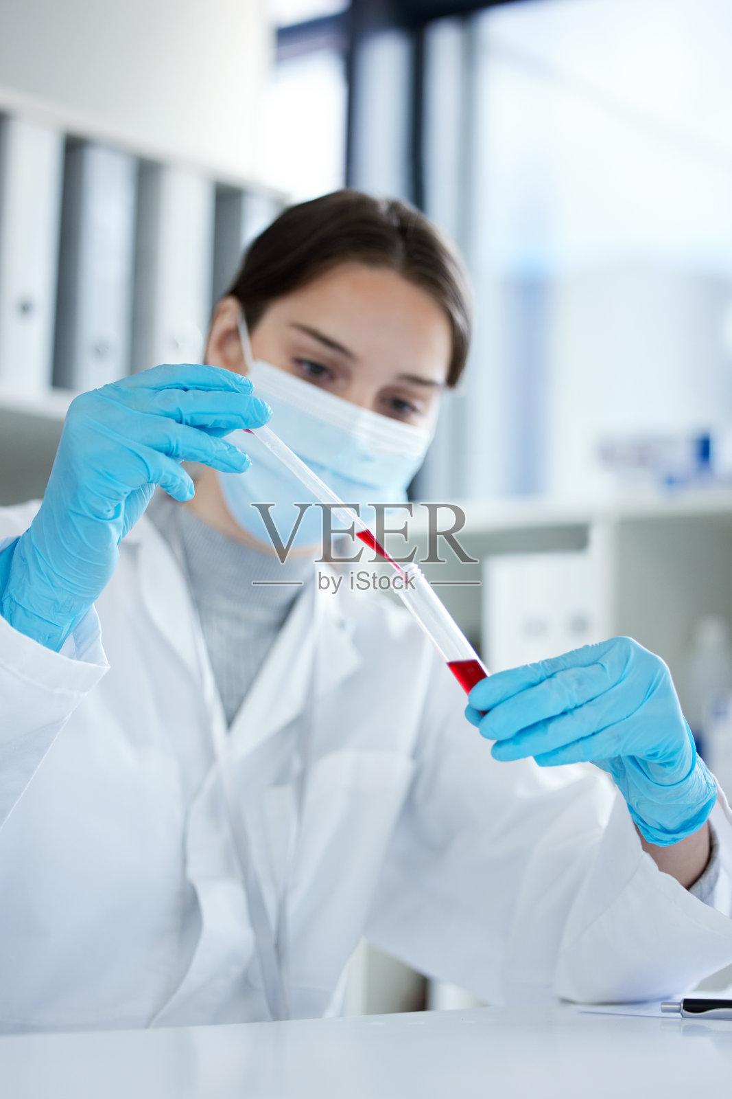 一名年轻女子在实验室中使用滴管和试管处理样本的特写镜头照片摄影图片