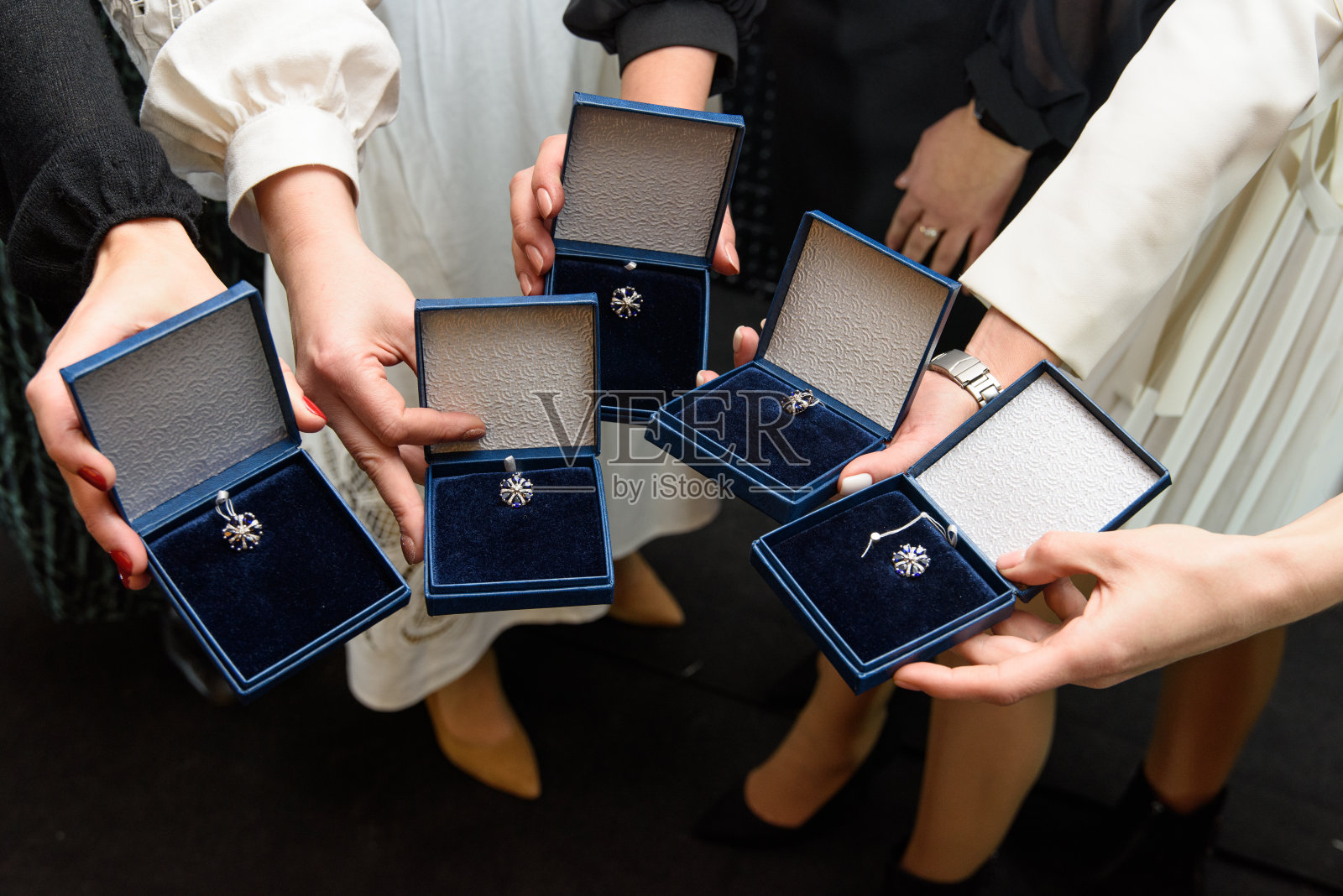 银首饰吊坠在蓝色礼品盒。女性的手拿着一个有银坠饰的盒子照片摄影图片