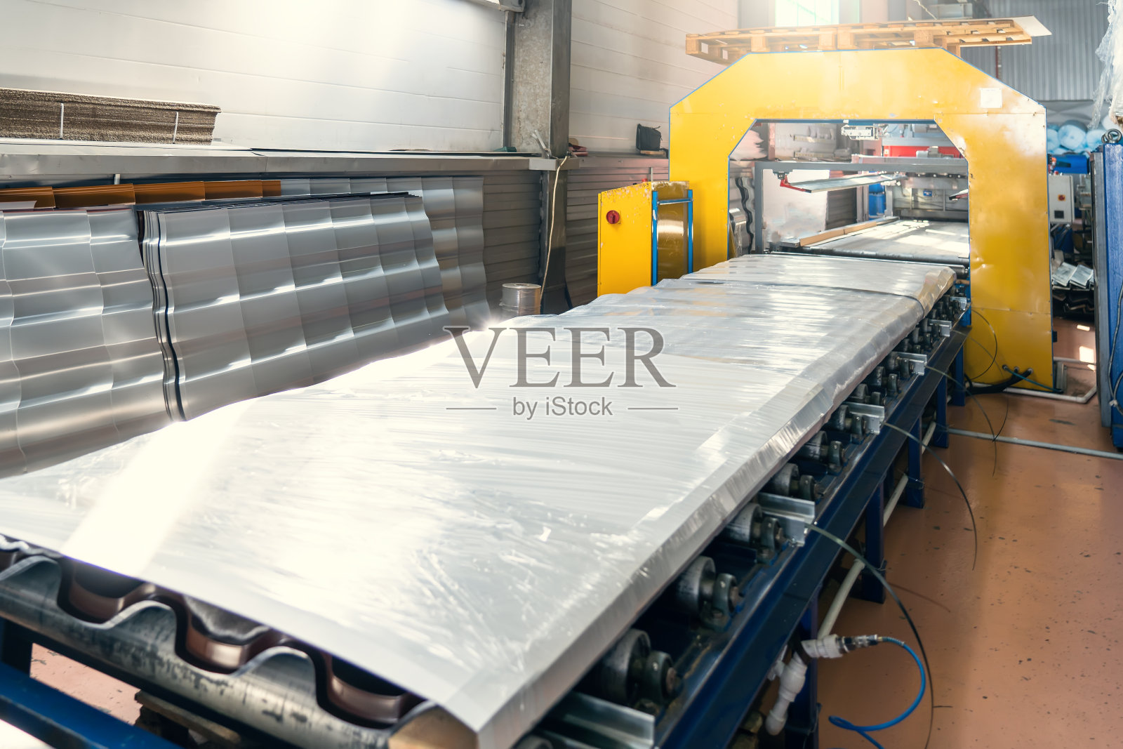 输送带与成品和包装金属屋面瓦生产在工厂仓库内部照片摄影图片