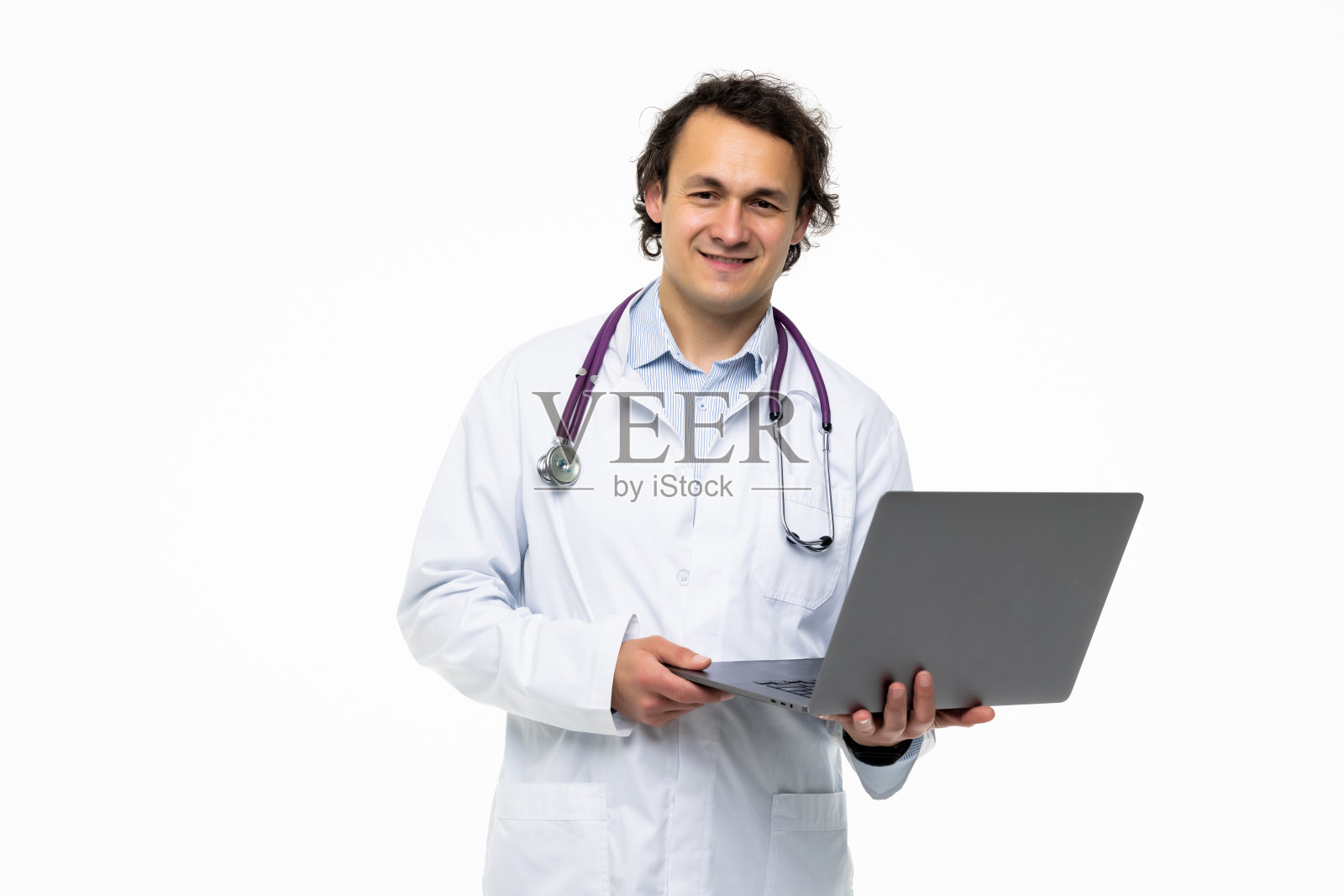 快乐的医生拿着笔记本电脑看着孤立在白色背景下的相机照片摄影图片