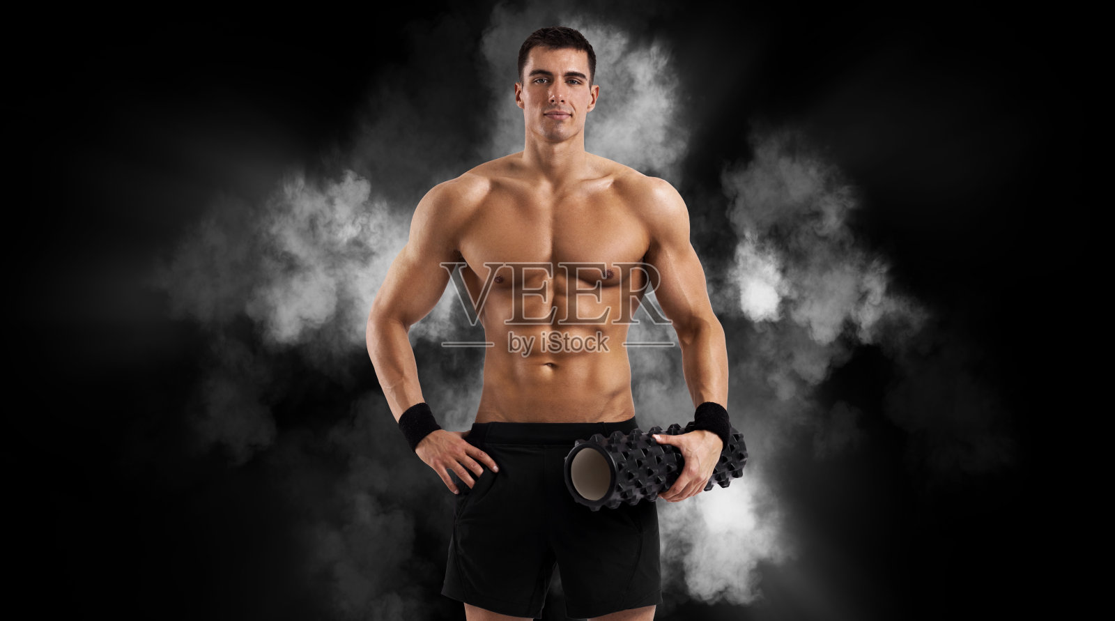 用工具和道具练习高级的男子。英俊的教练在做练习,轮转和滚动孤立在粉红色的背景上照片摄影图片