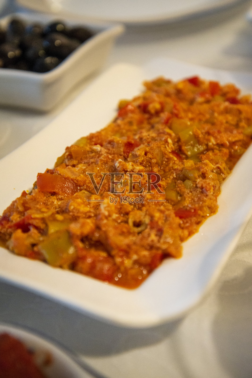 男人,传统的土耳其美食。它是由辣椒、西红柿、洋葱和鸡蛋做成的照片摄影图片