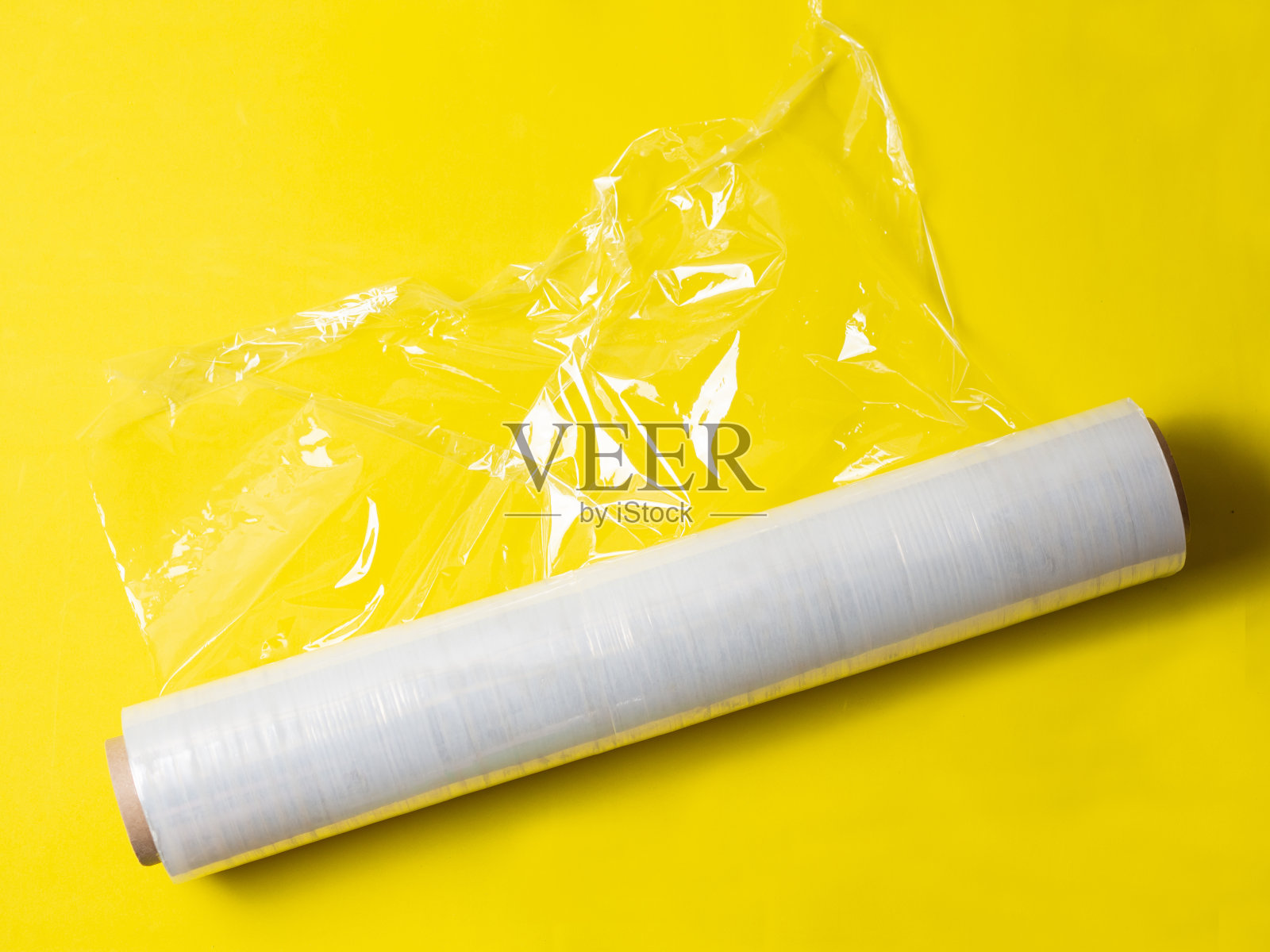 一卷用于包装的拉伸膜,背景为黄色孤立照片摄影图片