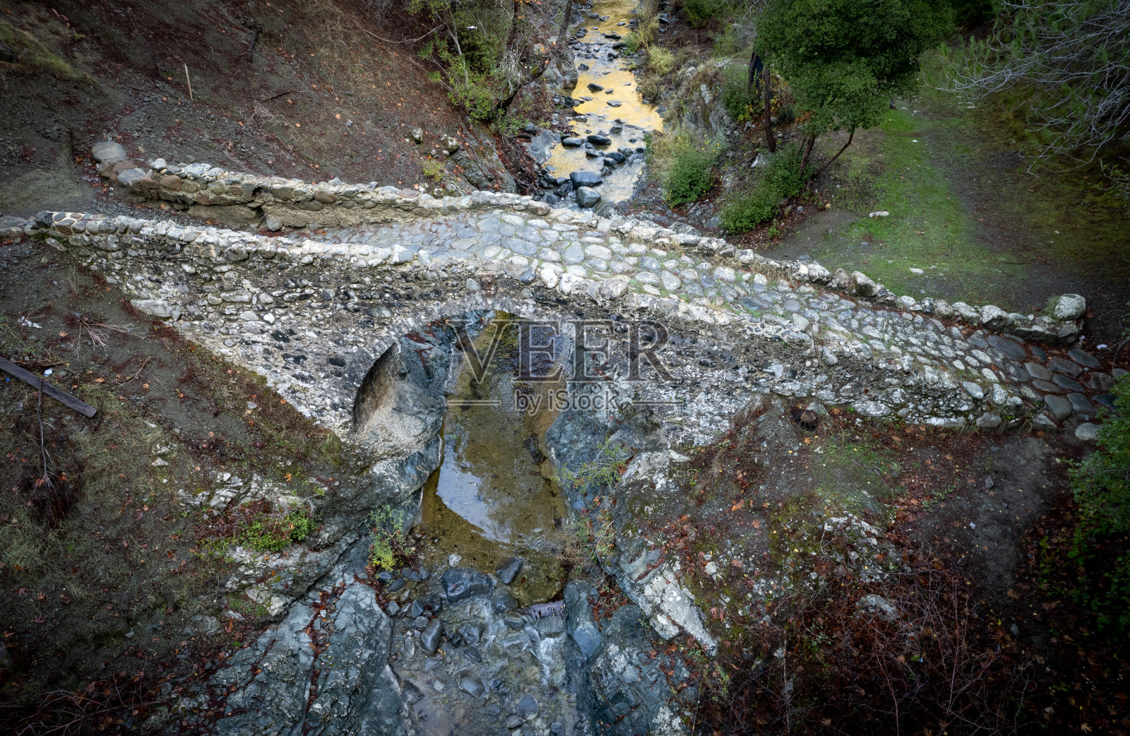 空中无人机拍摄的中世纪石桥与河水流动的场景。埃利亚桥Troodos塞浦路斯照片摄影图片