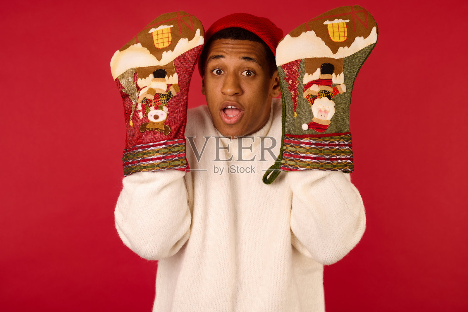 戴圣诞帽,手拿长筒袜的年轻人照片摄影图片