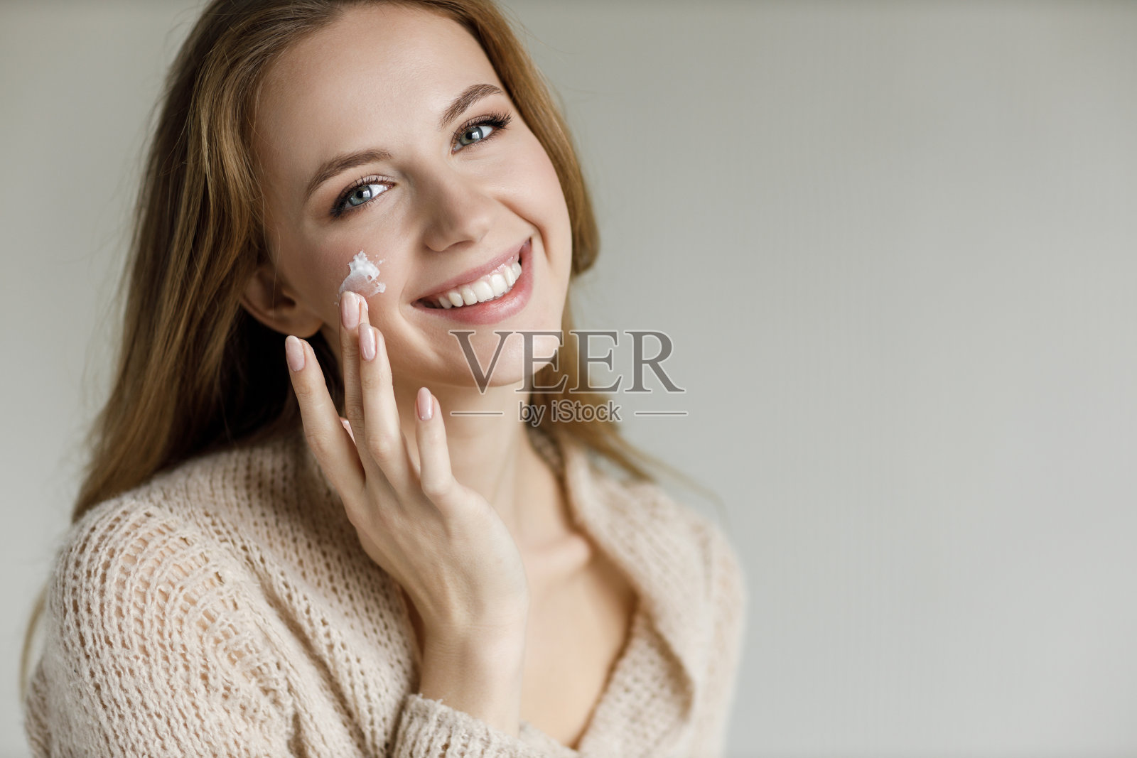 有吸引力的女孩的肖像长金发和灰色的眼睛孤立在灰色的背景,在工作室摆姿势照片摄影图片