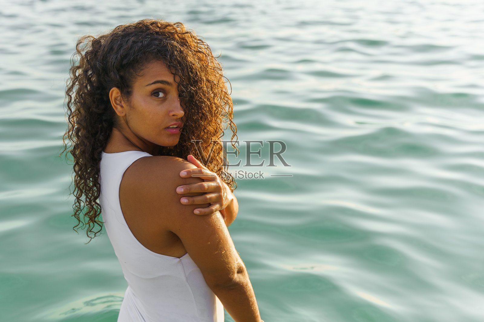 穿着泳衣的女人站在海里照片摄影图片