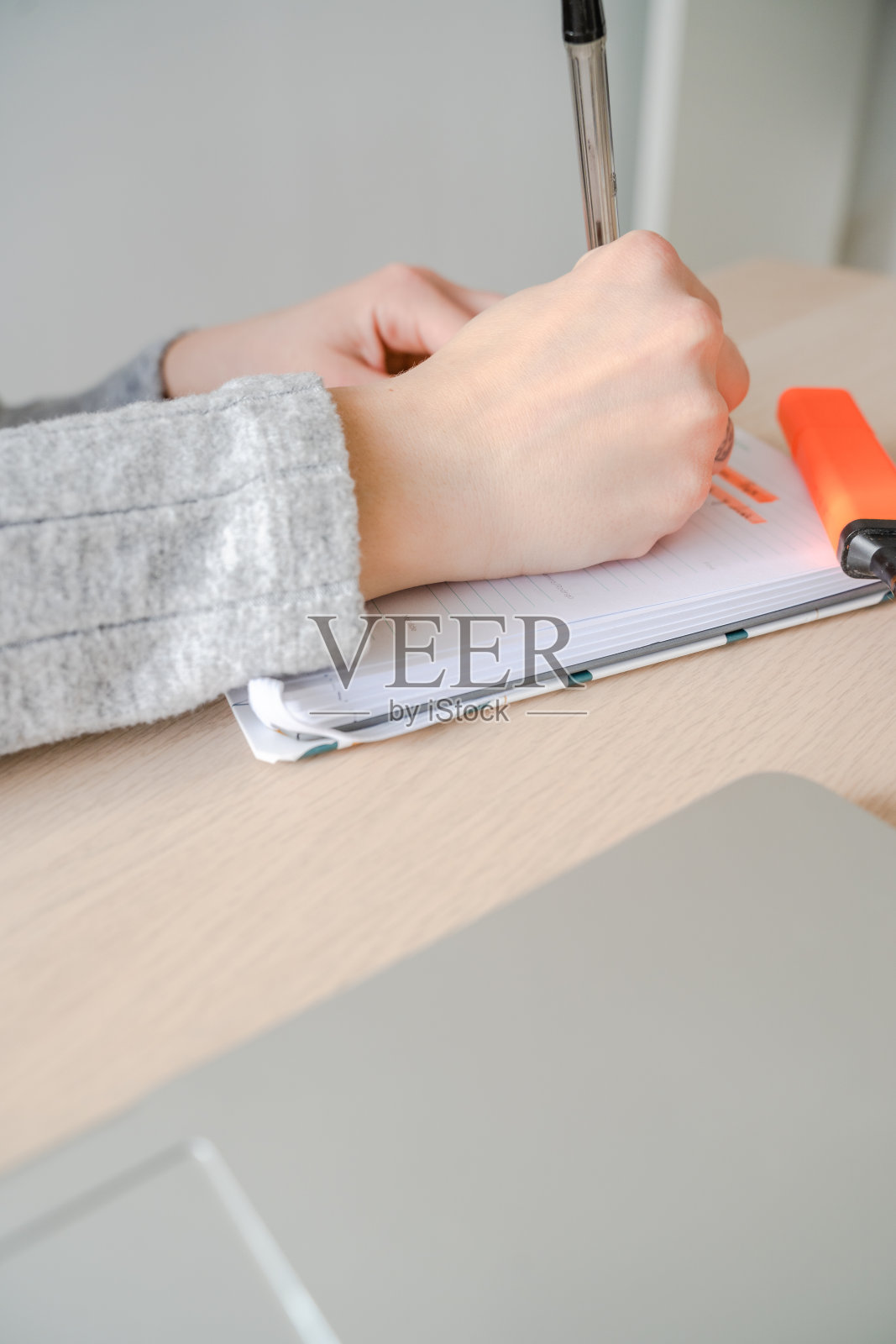 一名白人女性在工作时用笔在笔记本上写字。马略卡岛,西班牙照片摄影图片