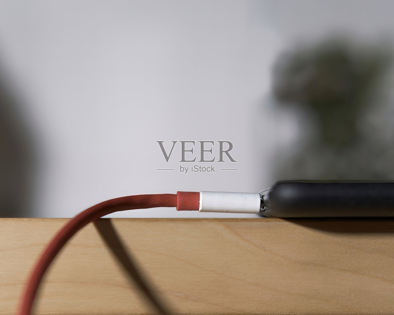 一张在木桌上插入充电器的智能手机的特写照片照片摄影图片