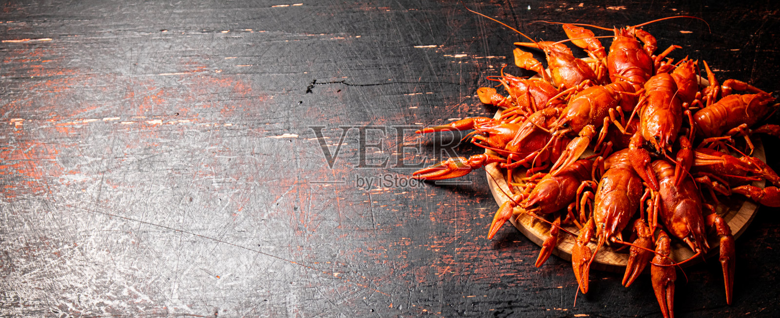 在圆切板上煮小龙虾。照片摄影图片