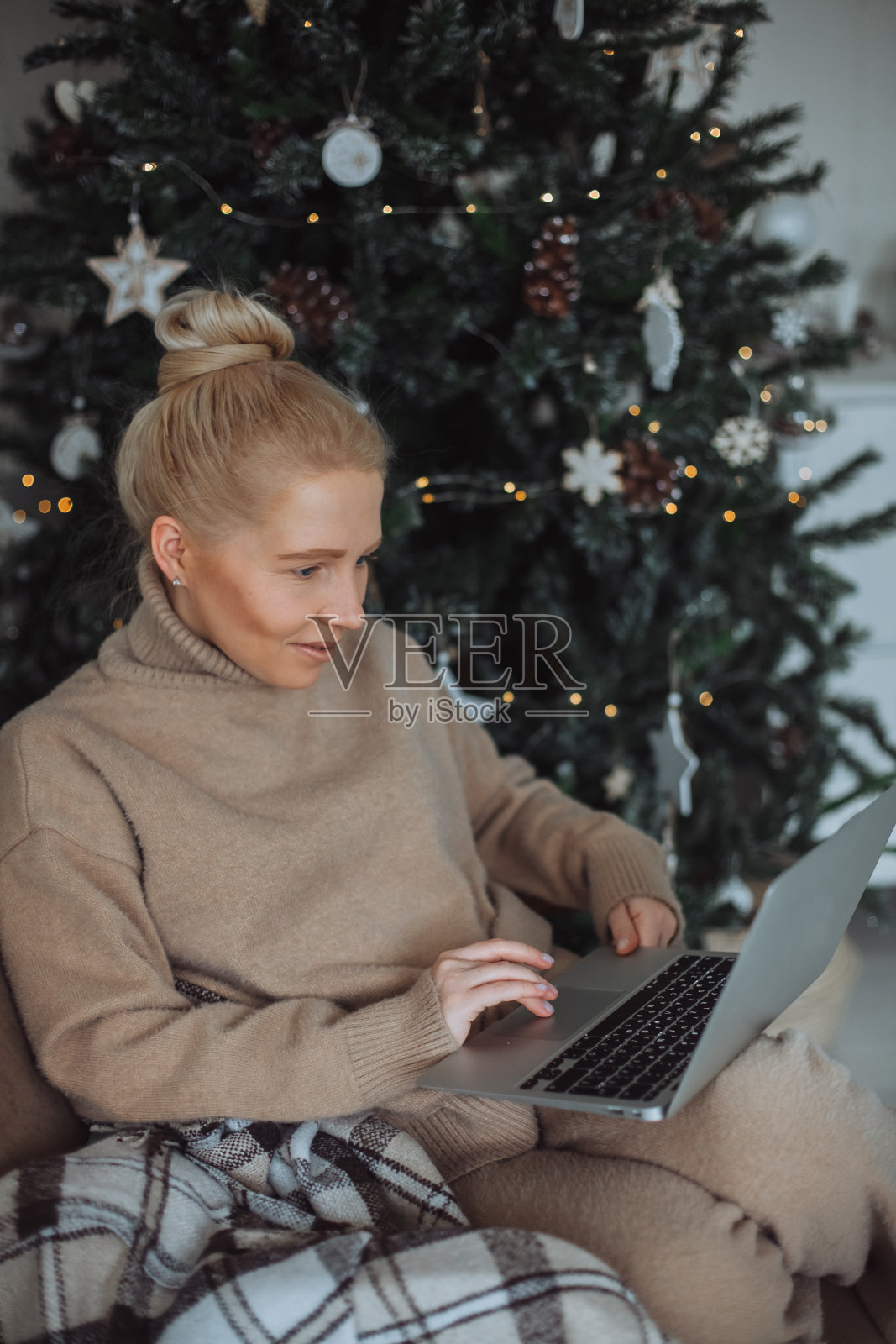 女孩在家里圣诞树旁用笔记本电脑照片摄影图片