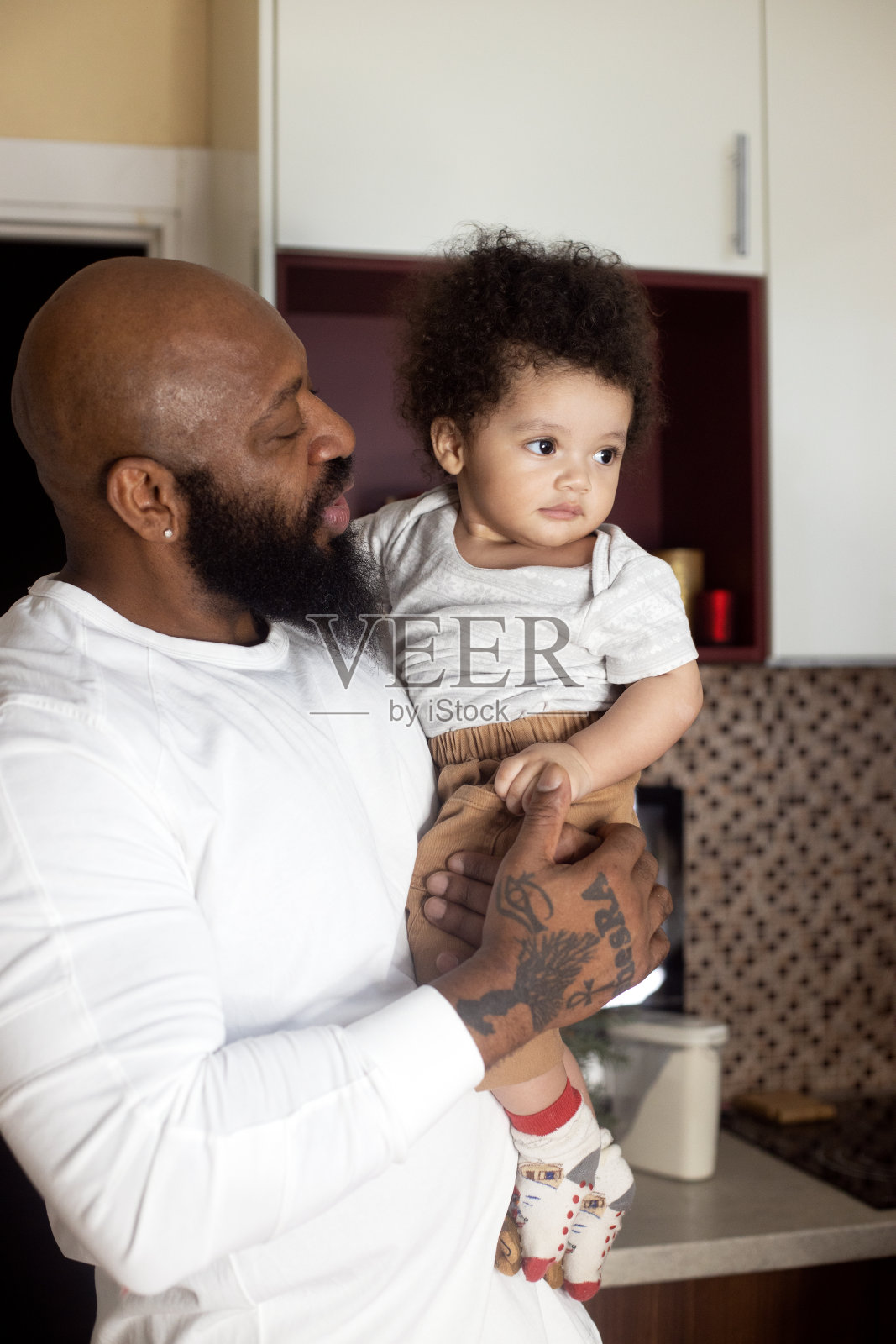 黑皮肤男人把他的混血孩子吊在手里。家庭多样化照片摄影图片