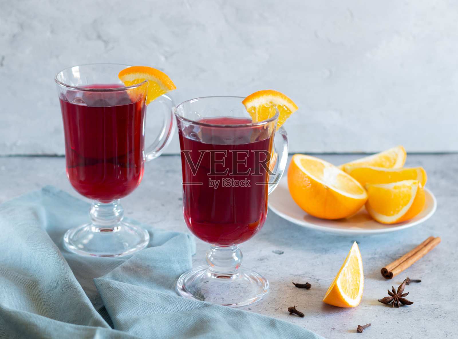 两杯热葡萄酒,橙子,香料,浅色背景,灰色纺织品照片摄影图片