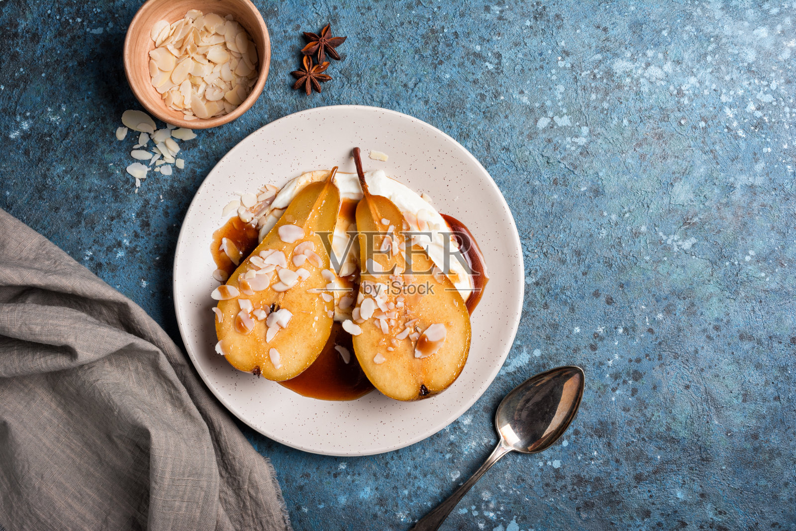 水果甜点配烤梨,焦糖酱,芝士奶油和杏仁片照片摄影图片