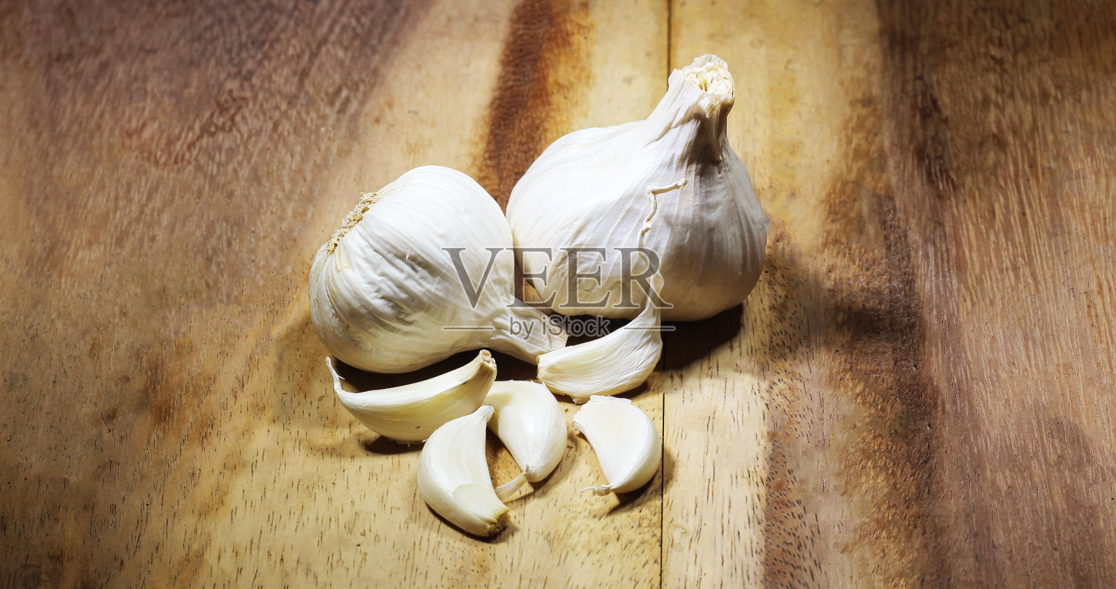 大蒜和它的鳞茎在木质纹理的背景上。选择焦点与文本的复制空间。照片摄影图片