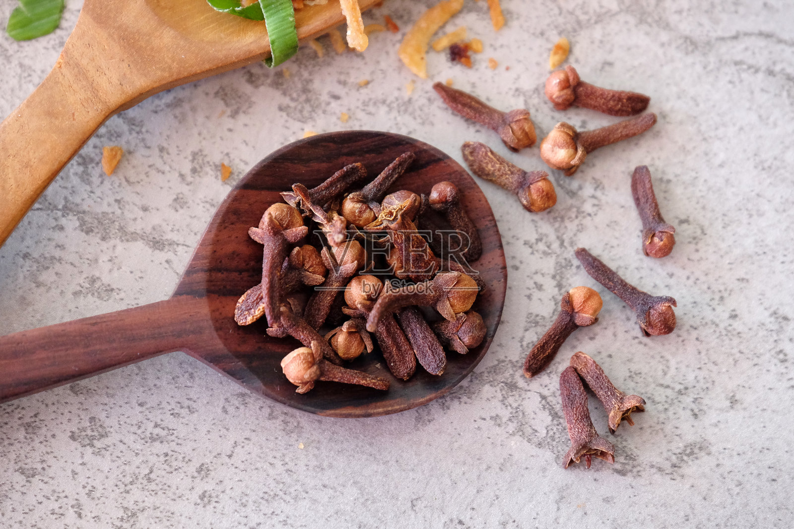 把丁香放在木勺上。照片摄影图片