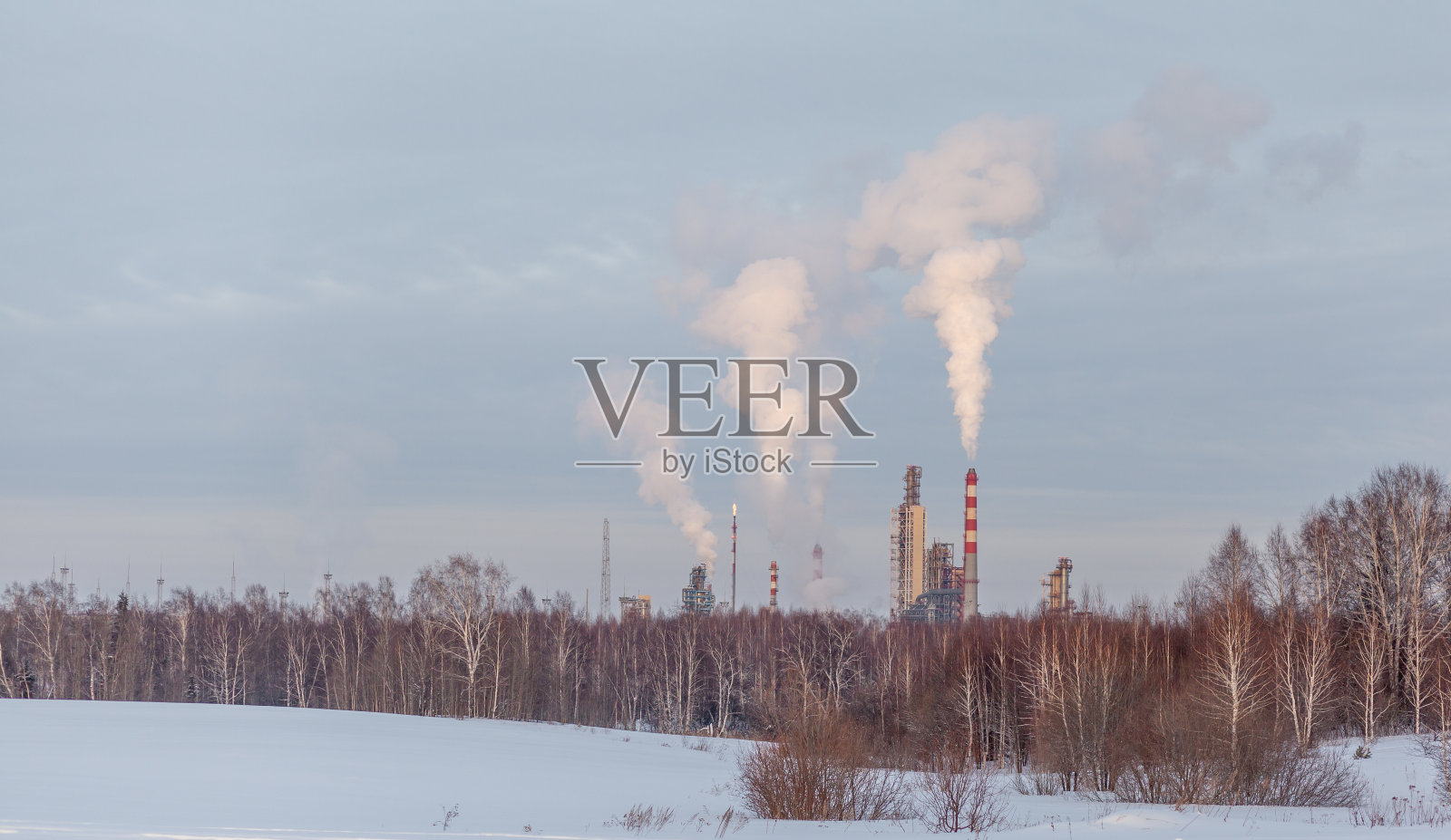 石化厂的工作烟从烟囱里冒出来。照片摄影图片