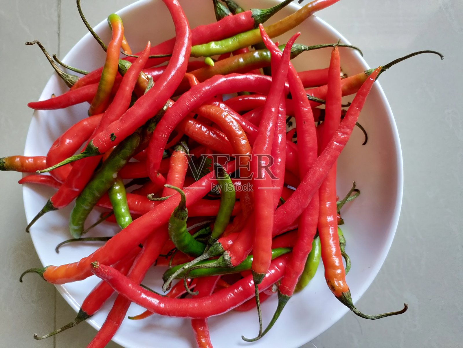 白色底色的红辣椒。照片摄影图片