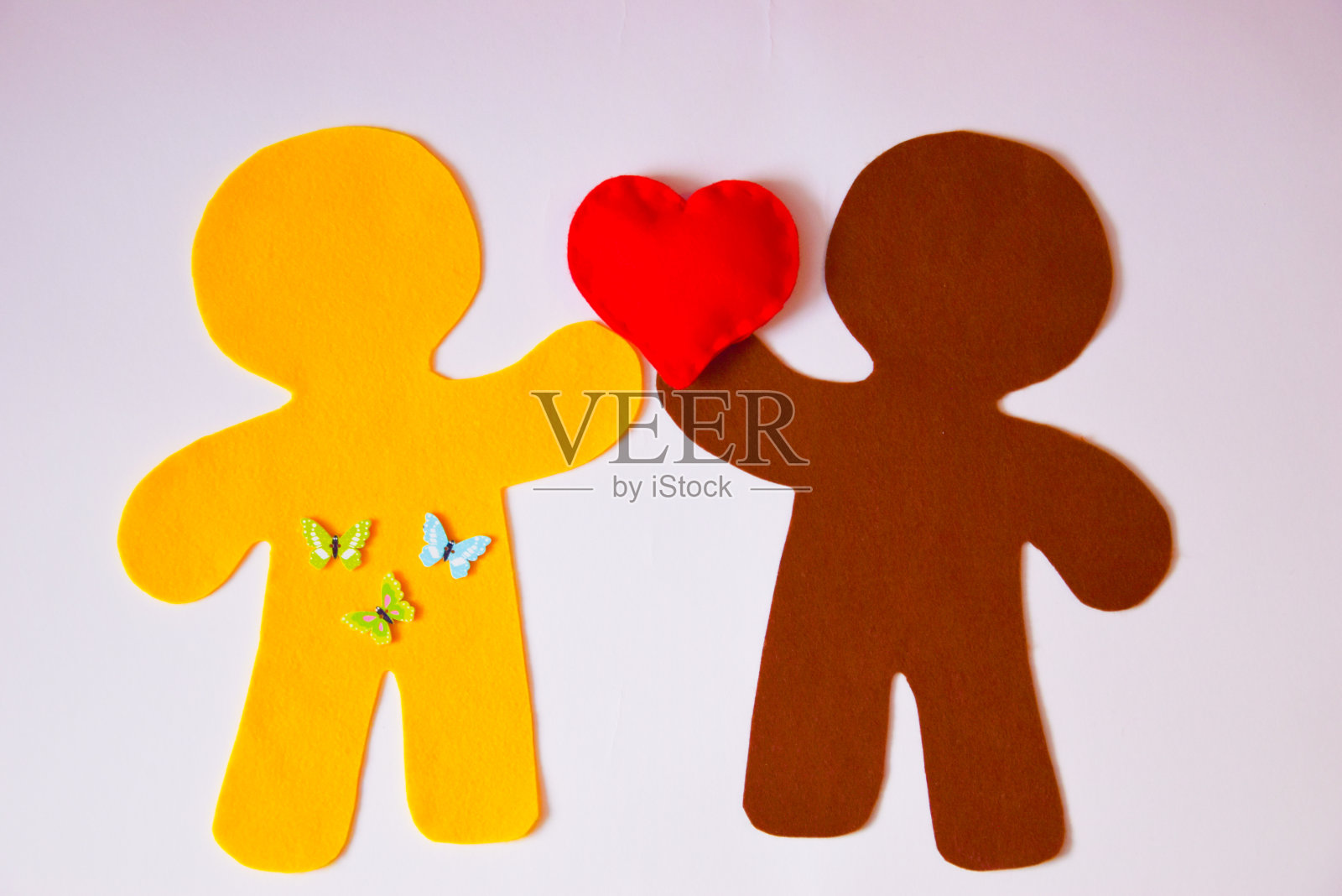 两个人的剪影,用毛毡做成,手里拿着一颗心照片摄影图片