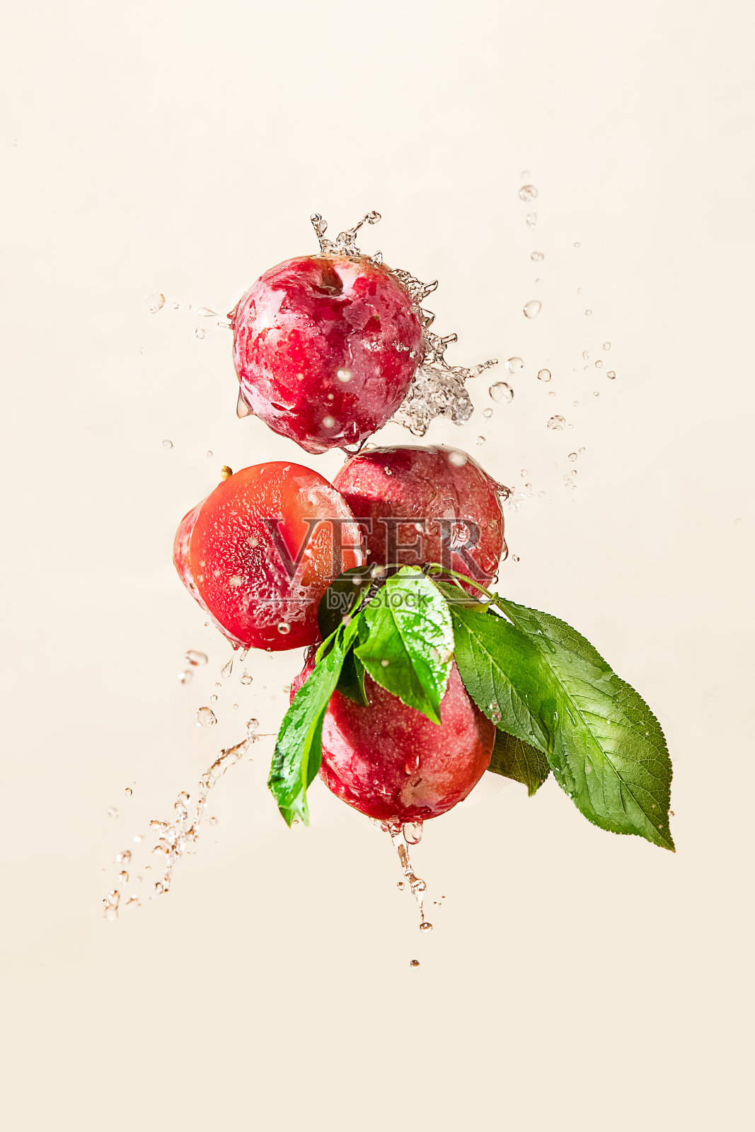 新鲜的有机梅子喷洒干净的水隔离在朴素的背景,健康的饮食和生活方式的理念,天然的食物和水果照片摄影图片