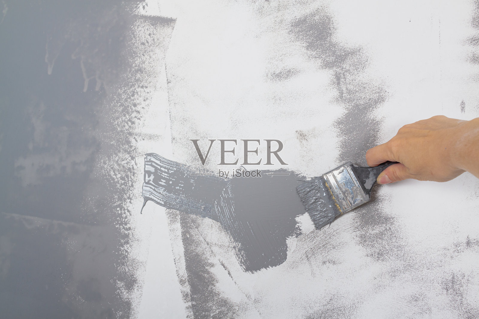 用灰色的刷子刷一面白色的墙照片摄影图片