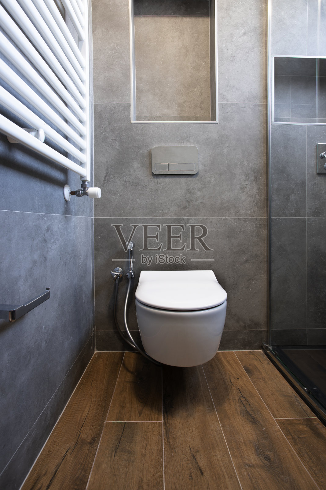 漂浮的厕所在设计师的浴室与灰色的石墙和木地板照片摄影图片