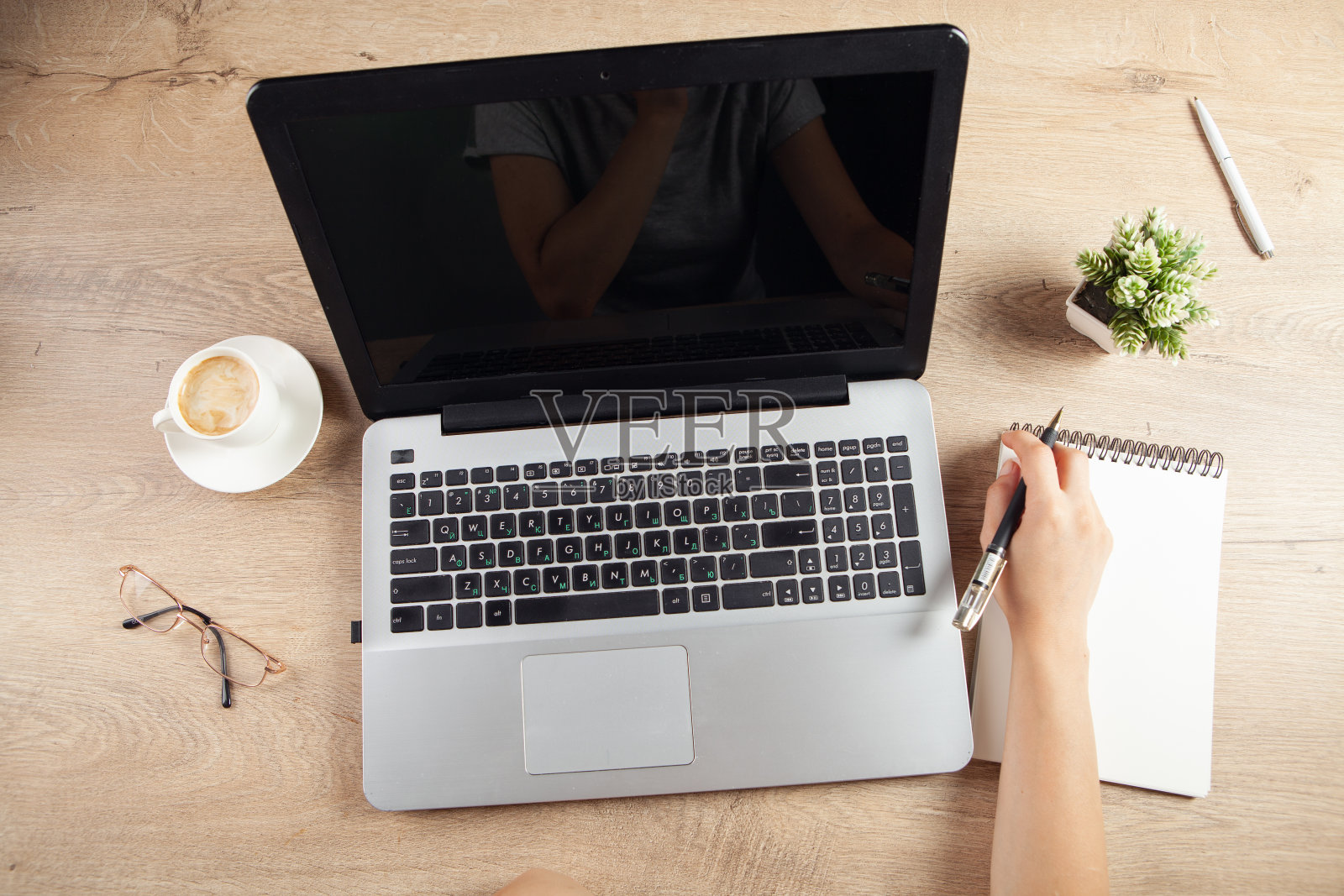 小女孩在工作台前的笔记本上记笔记照片摄影图片