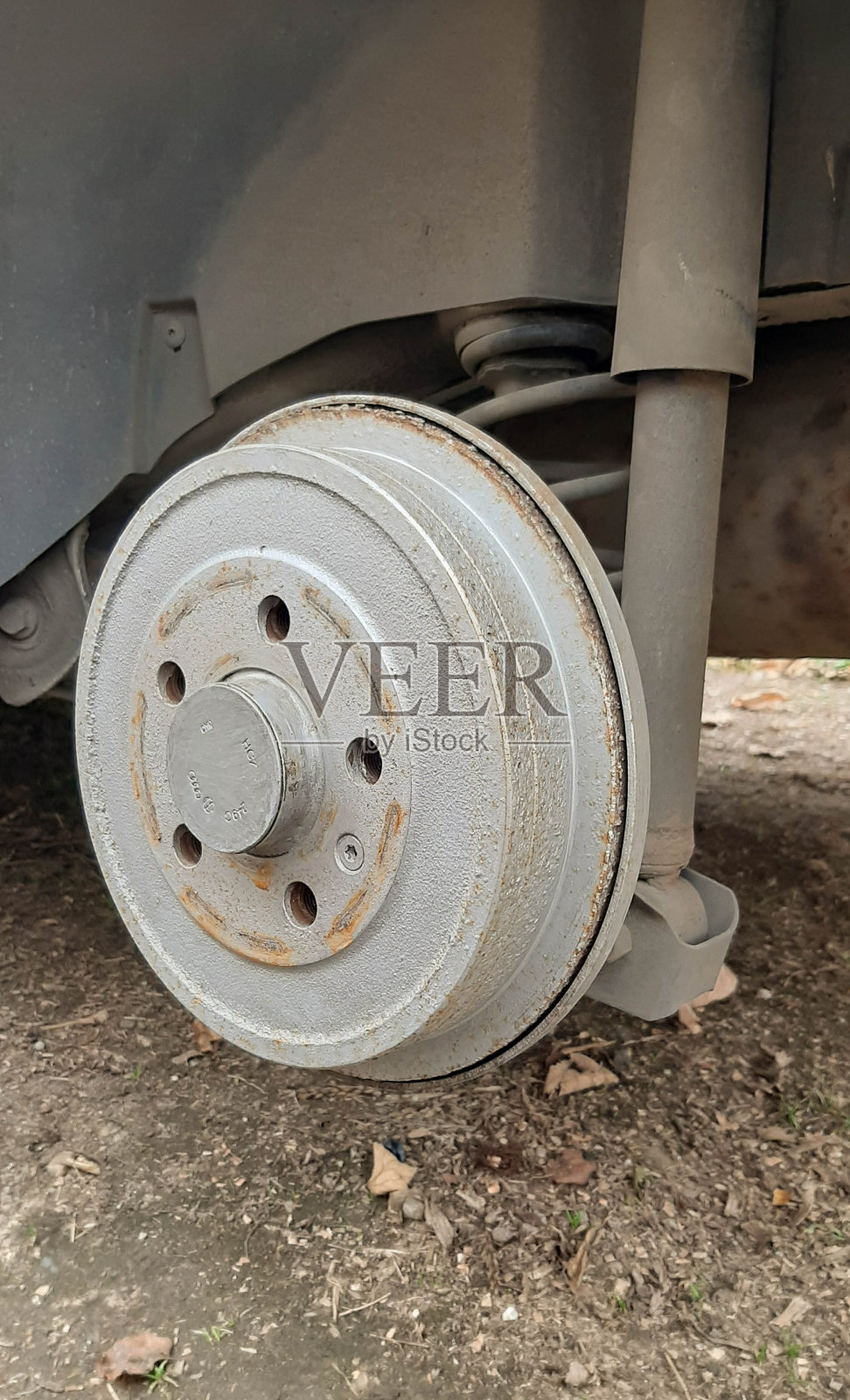 红色制动鼓的特写,轮式汽车的检查和修理。照片摄影图片