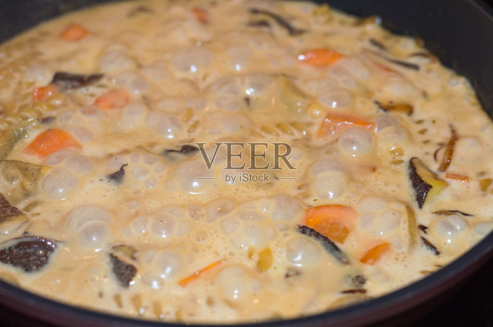 锅里放蘑菇酸奶油酱。照片摄影图片