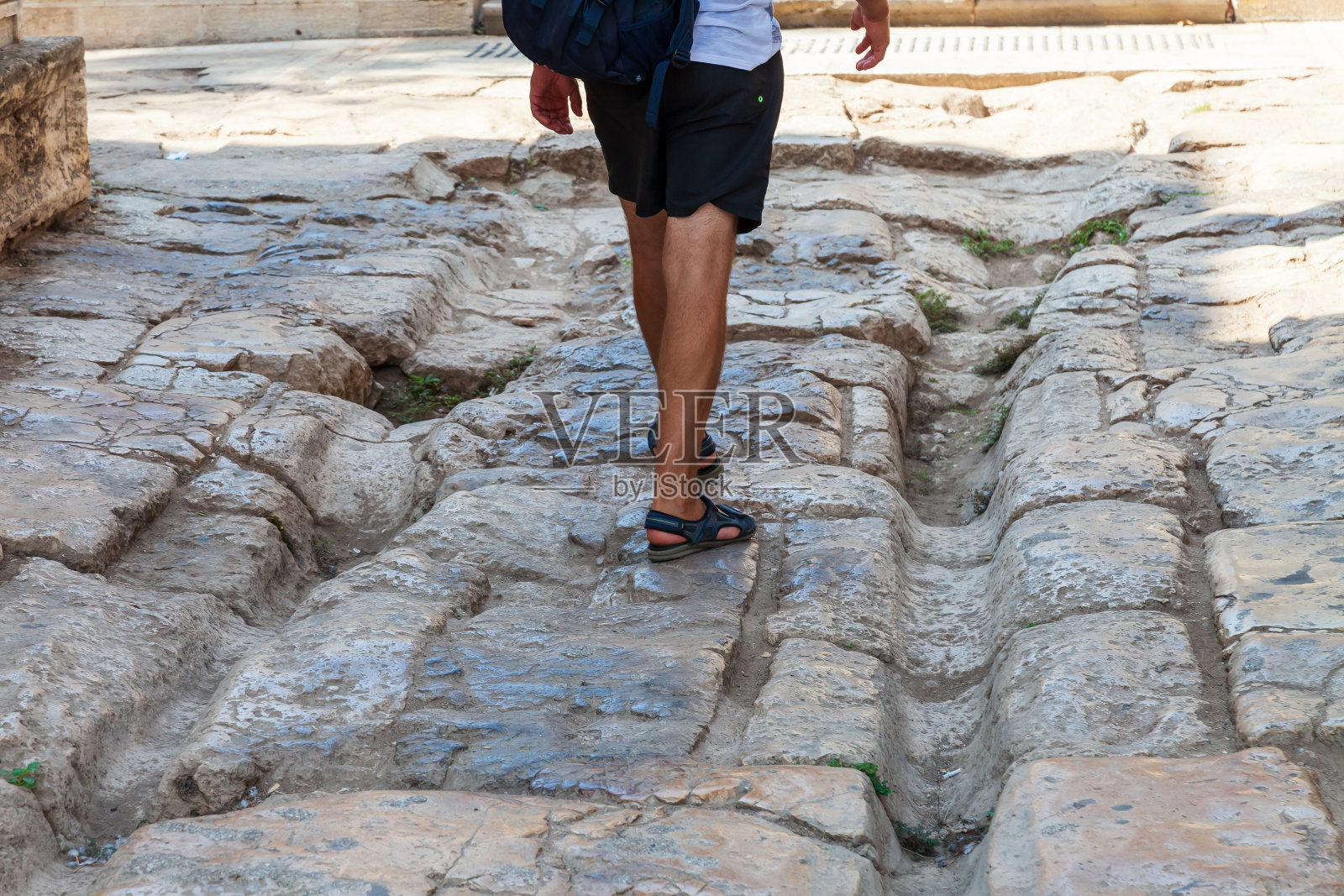 土耳其安塔利亚古城的一条古道,游客们从哈德良门下面走过,上面是古希腊马车和战车的镂空轨道。历史地标。照片摄影图片