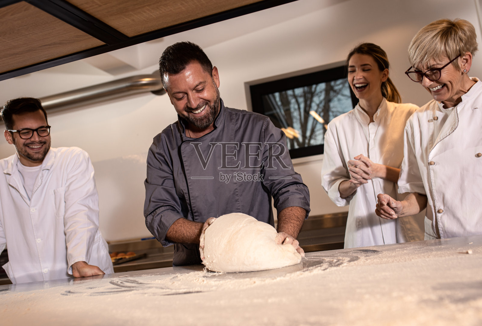 在现代制造业中为面包准备面团的面包师。照片摄影图片