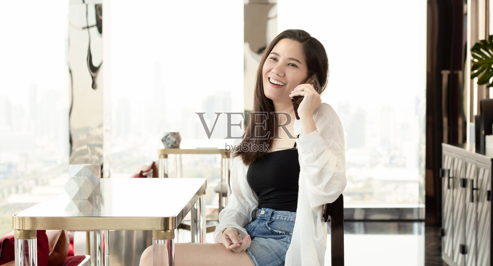 亚洲美女在手机上,休闲度假时轻松微笑,幸福快乐照片摄影图片