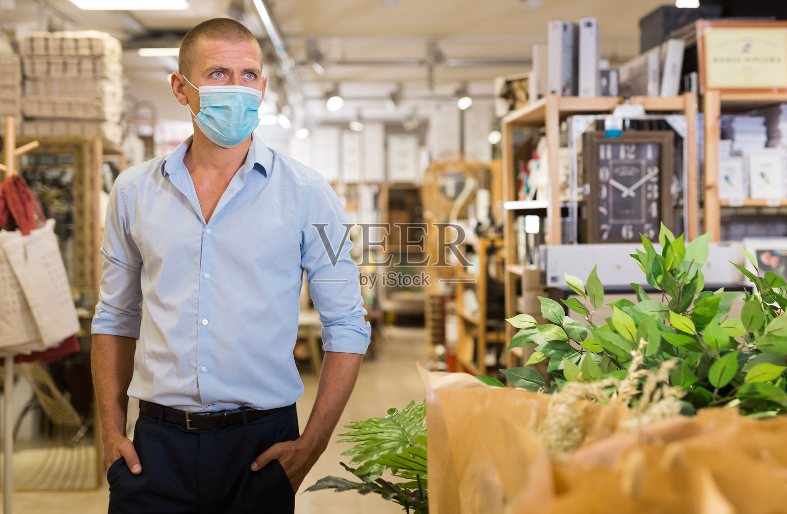 戴面具的男人在商店里挑选装饰品照片摄影图片