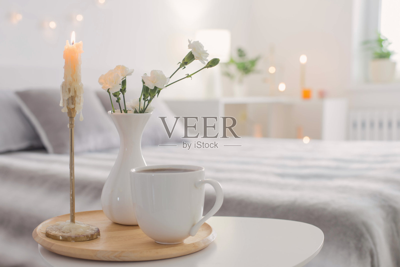 卧室桌子上的一杯咖啡和花瓶里的白花照片摄影图片