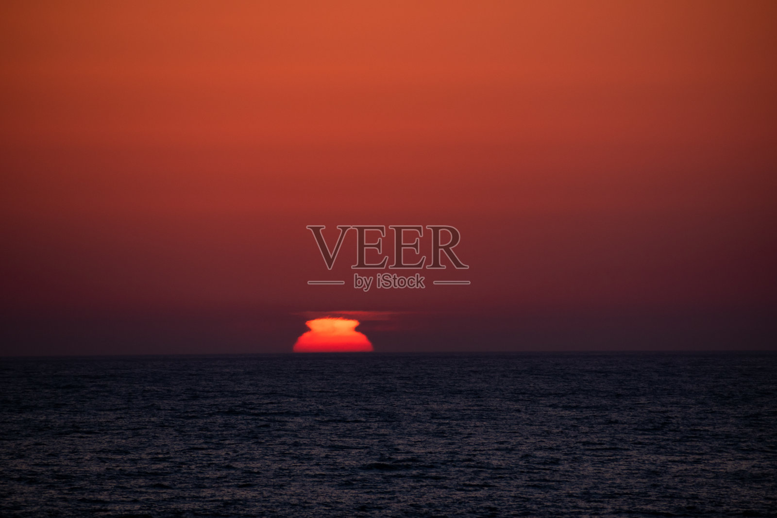 落日因海市蜃楼而变形照片摄影图片