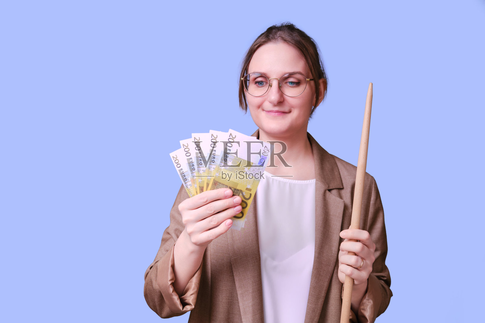 微笑的女老师用蓝色背景的欧元钱,复印空间照片摄影图片