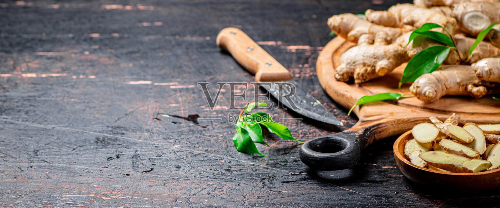 木盘上的新鲜生姜片。照片摄影图片