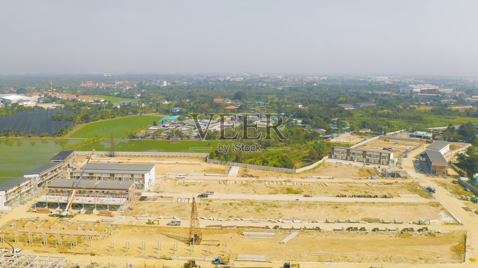 俯视图的干燥地面粗糙裂缝的土地与沙子的工厂建设工地。干旱图案纹理背景。照片摄影图片