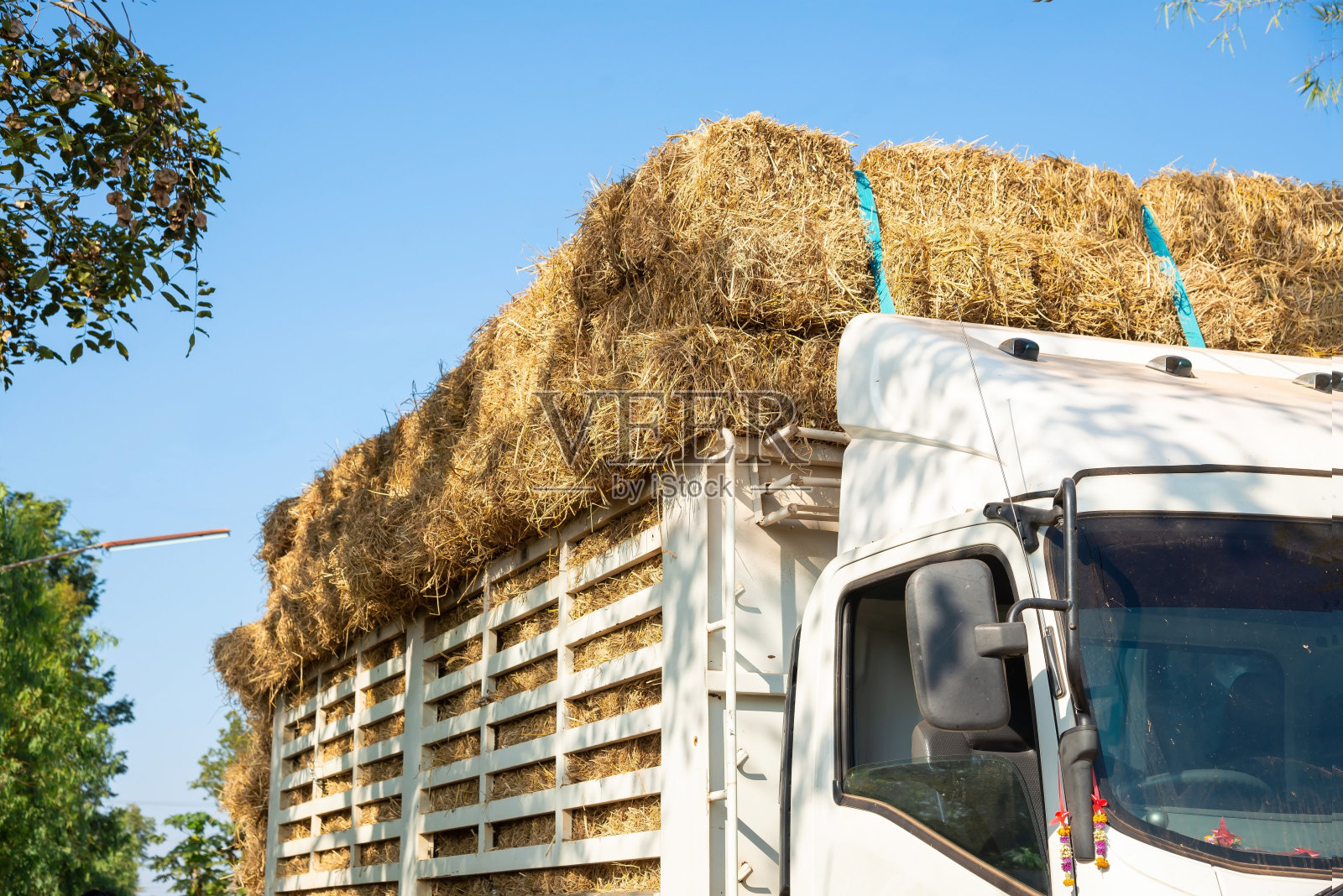 装载稻草捆的重型拖车。照片摄影图片