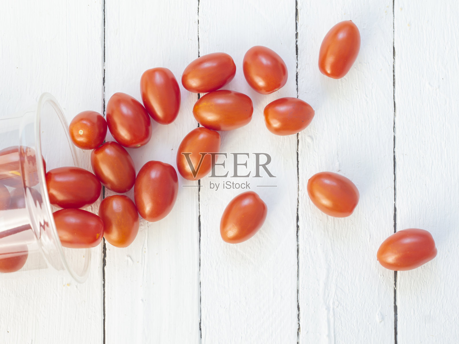 红色长方形圣女果散落在白色背景的木板上。俯视图照片摄影图片