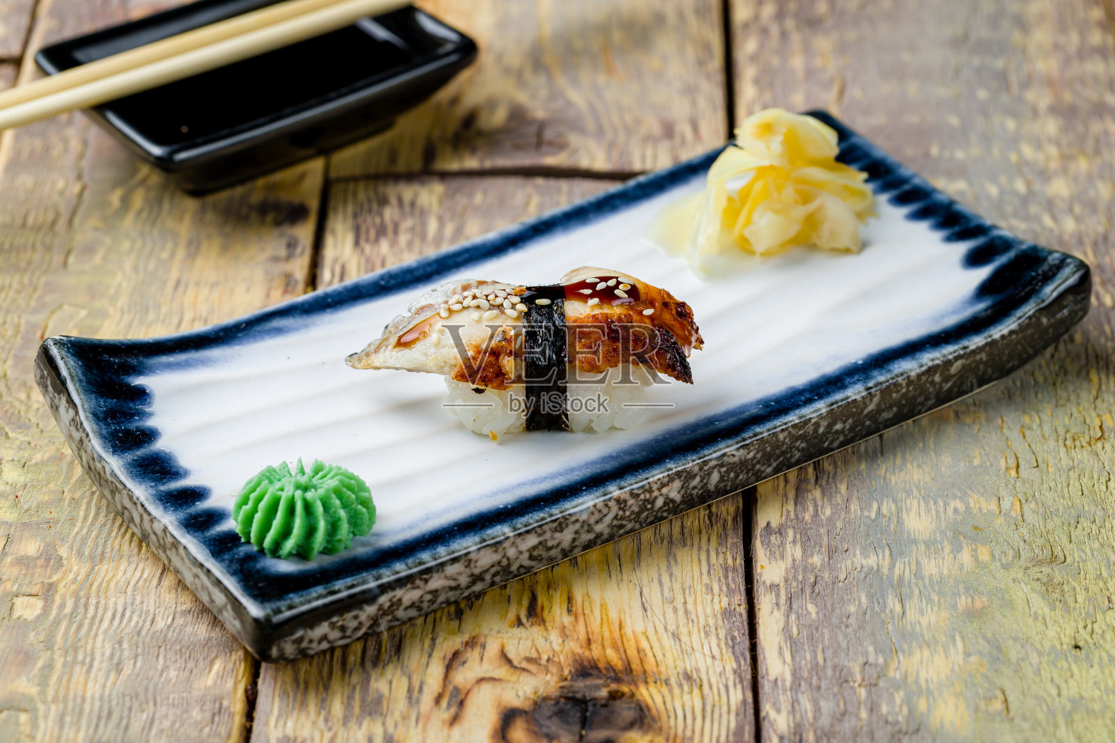 木桌上盘子里的寿司鳗鱼照片摄影图片