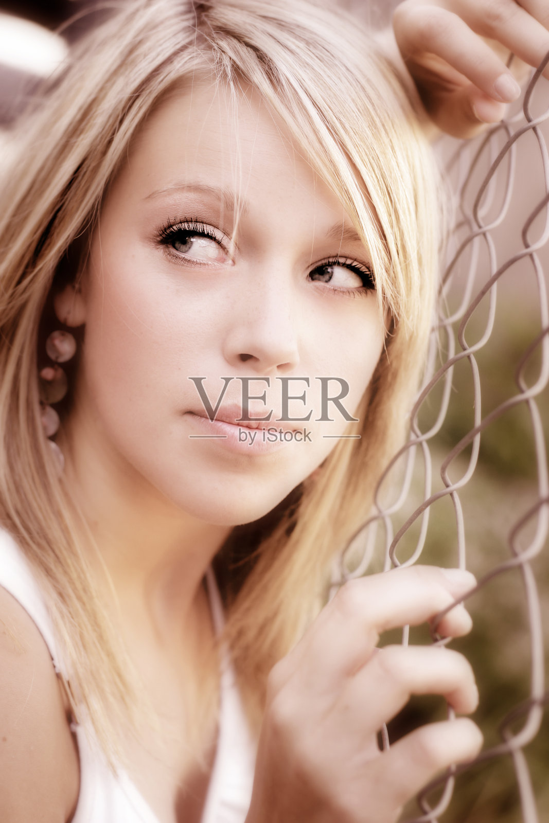 年轻女子在铁丝网前摆姿势照片摄影图片