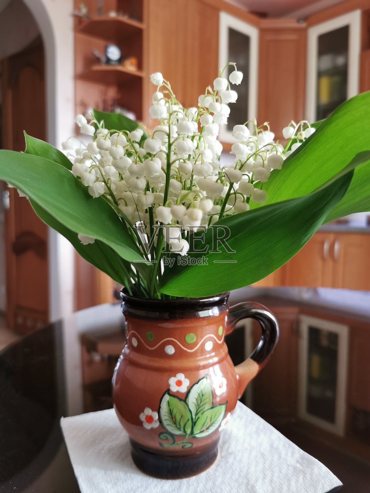 早春时节,厨房桌上花瓶里的铃兰照片摄影图片