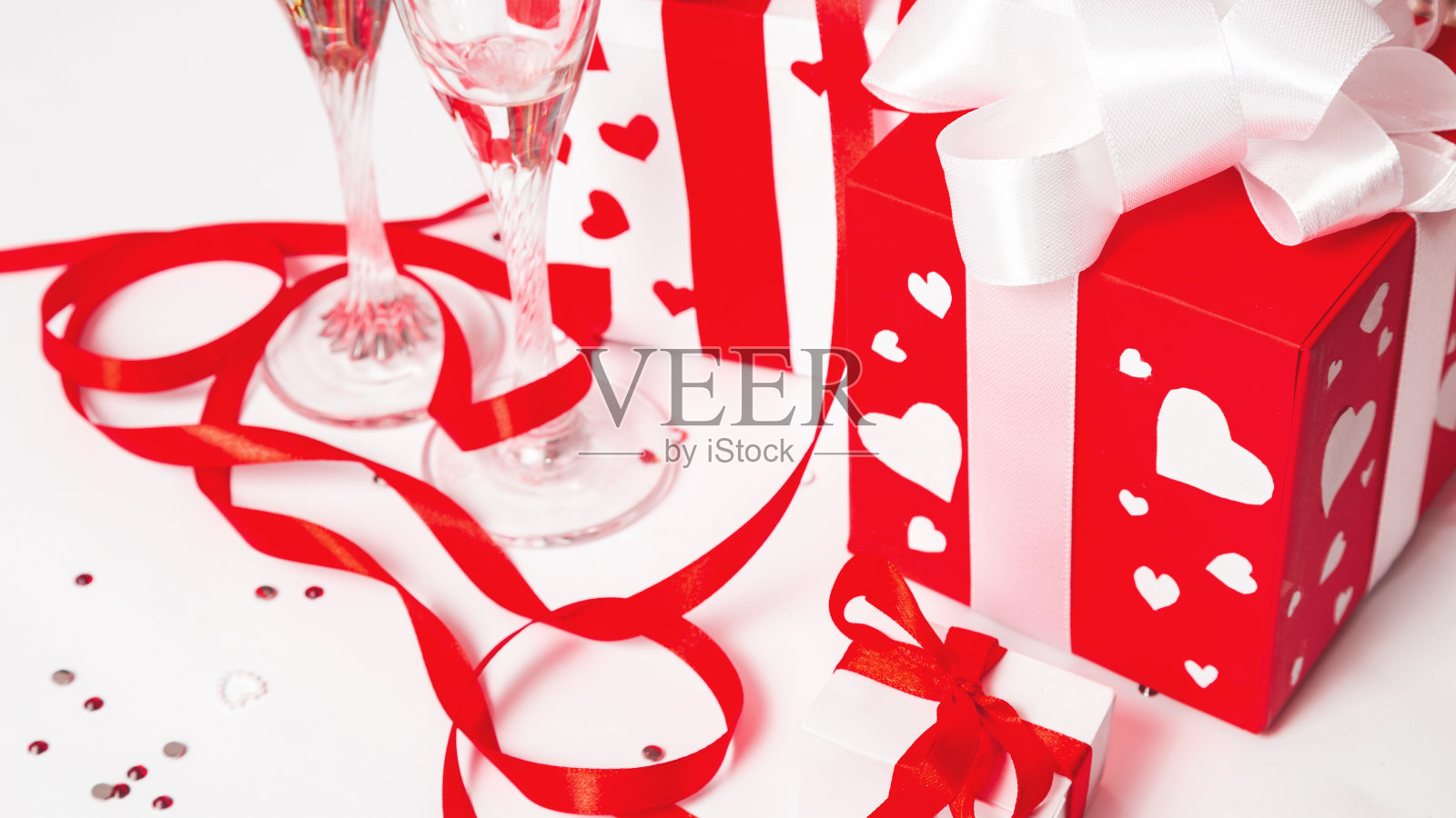 情人节礼物盒与红色丝带蝴蝶结,两个杯子在白色的背景。为情人节的横幅设计。爱情和浪漫的概念。照片摄影图片